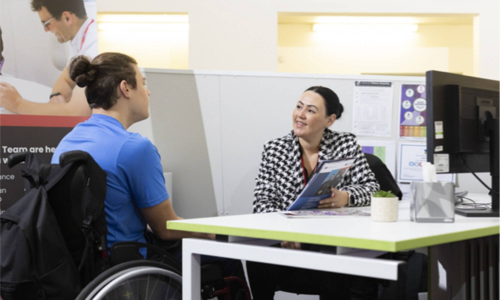 lady at computer talking to another lady